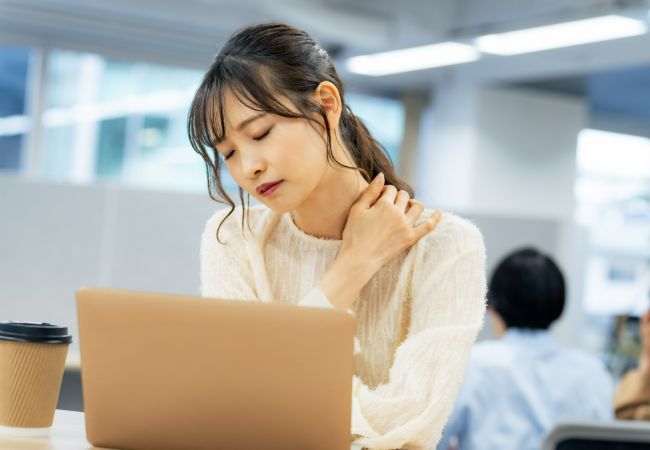肩の痛みを感じる女性