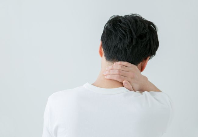 首の痛みを感じる男性
